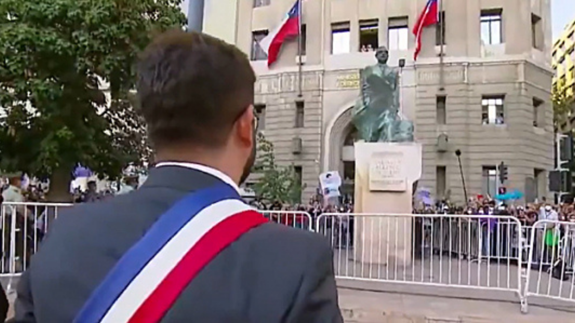 Gabriel Boric saúda estátua de Allende. ele aparece de costas para a câmera e em frente à estátua de Allende.