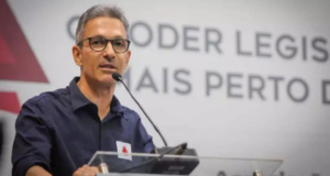 Zema ignora greve e decide não atender reivindicações de servidores. Foto do governador com camisa azul marinho, falando em um púlpito, com óculos de grau e cabelo grisalho liso