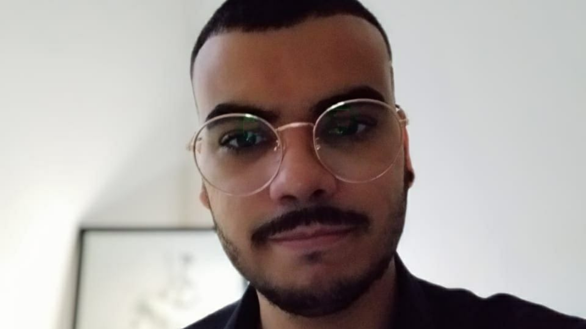 Carlos Eduardo foi um dos atendidos pelo ProUni. Ele usa barba, óculos de grau com lentes redondas e cabelo preto ralo.