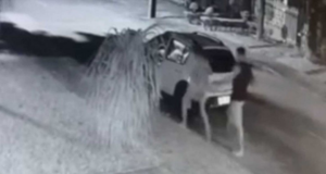 Delegado explica como está o caso do mendigo que apanhou de personal. Foto de câmera de segurança mostrando o carro, o marido e a esposa, um ao lado do outro.