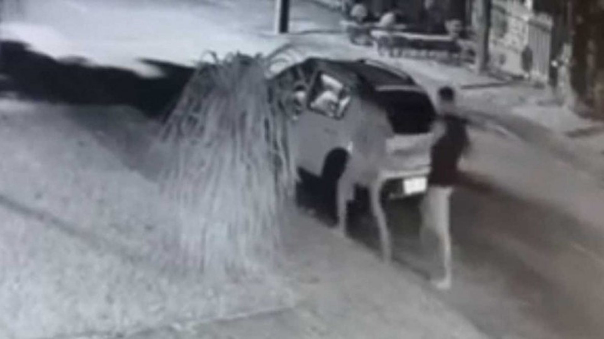 Delegado explica como está o caso do mendigo que apanhou de personal. Foto de câmera de segurança mostrando o carro, o marido e a esposa, um ao lado do outro.