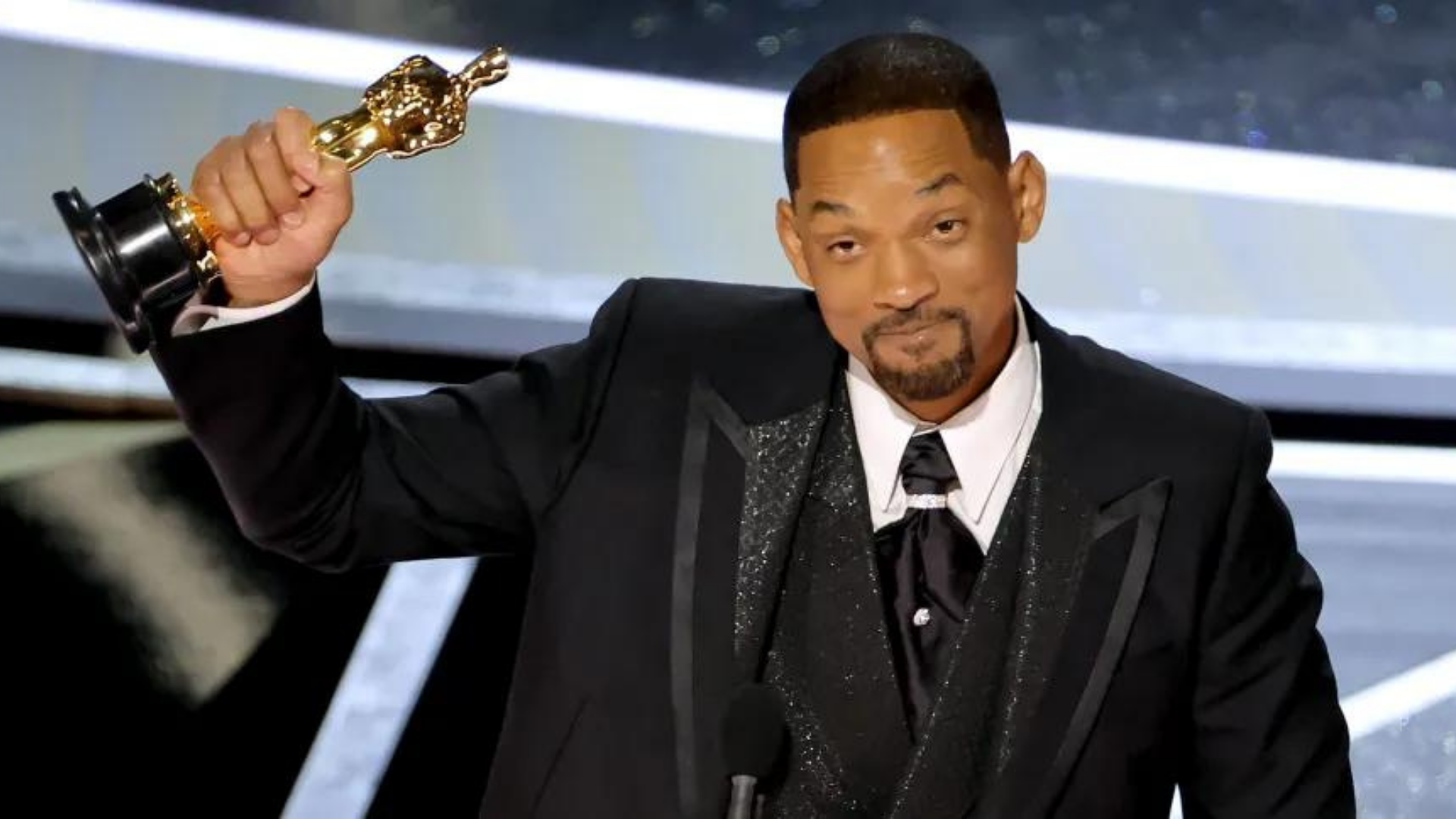 Academia diz que Will Smith foi convidado a se retirar do Oscar, mas se recusou. Foto de Smith sorrindo segurando o troféu do oscar com a mão direita.