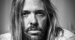 Taylor Hawkins tinha mais de dez drogas no corpo, diz polícia. Foto do baterista com expressão séria e cabelo longo liso.