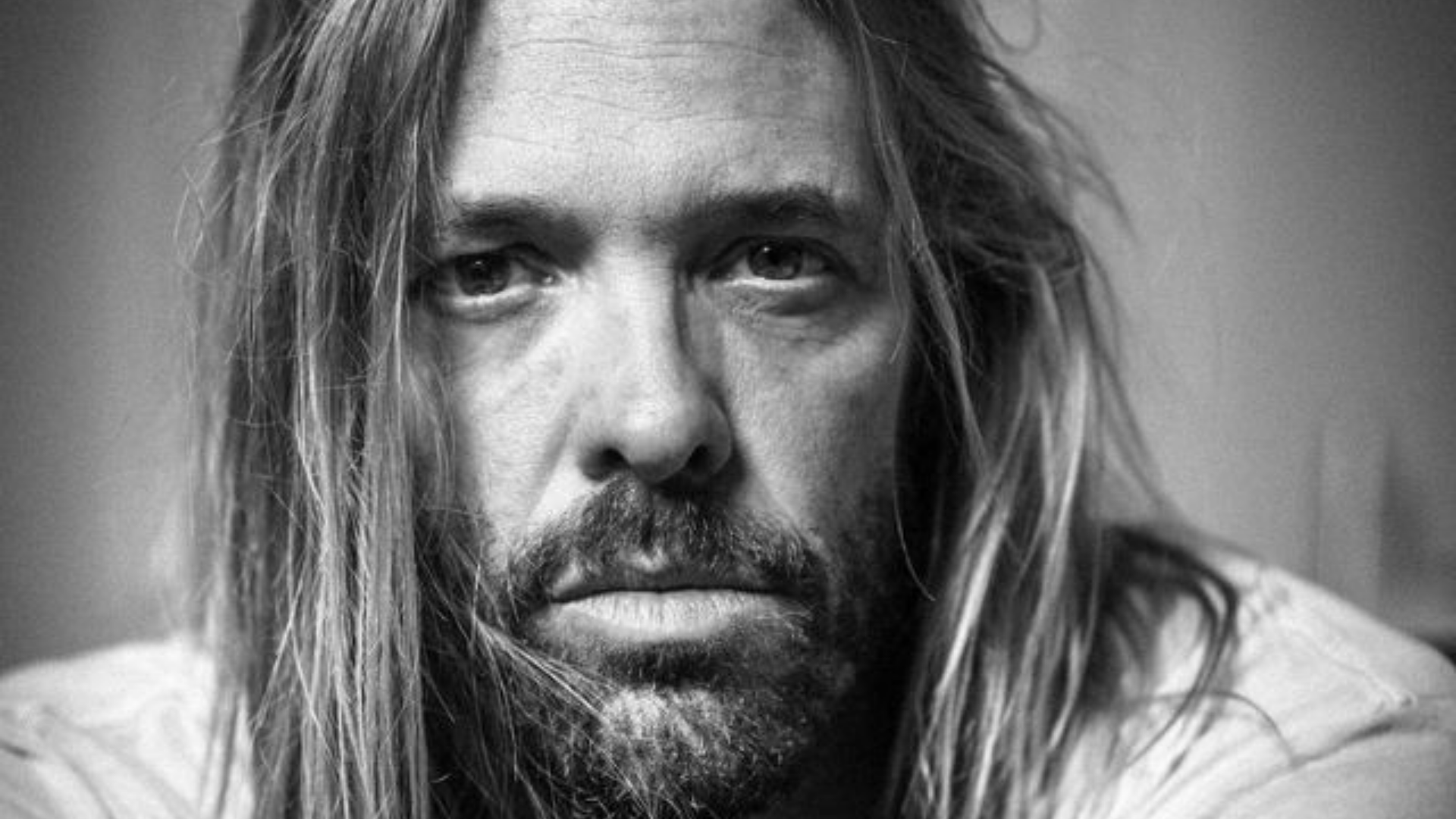 Taylor Hawkins tinha mais de dez drogas no corpo, diz polícia. Foto do baterista com expressão séria e cabelo longo liso.