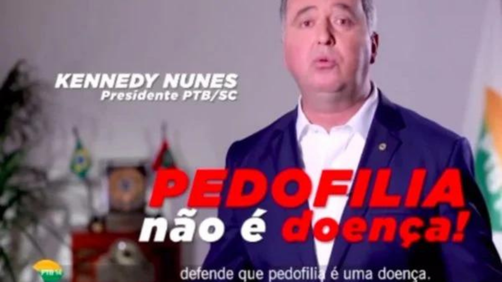 Justiça proíbe circulação de propaganda do PTB que associa esquerda à pedofilia. deputado aparece em print de vídeo usando terno azul e falando. Na tela há escrito a frase "Pedofilia não é doença", que seria supostamente dirigida à esquerda.