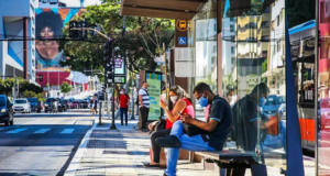 Observatório Covid-19 diz que relaxamento nas medidas de proteção é prematuro. Foto de pessoas em uma parada de ônibus em São Paulo.