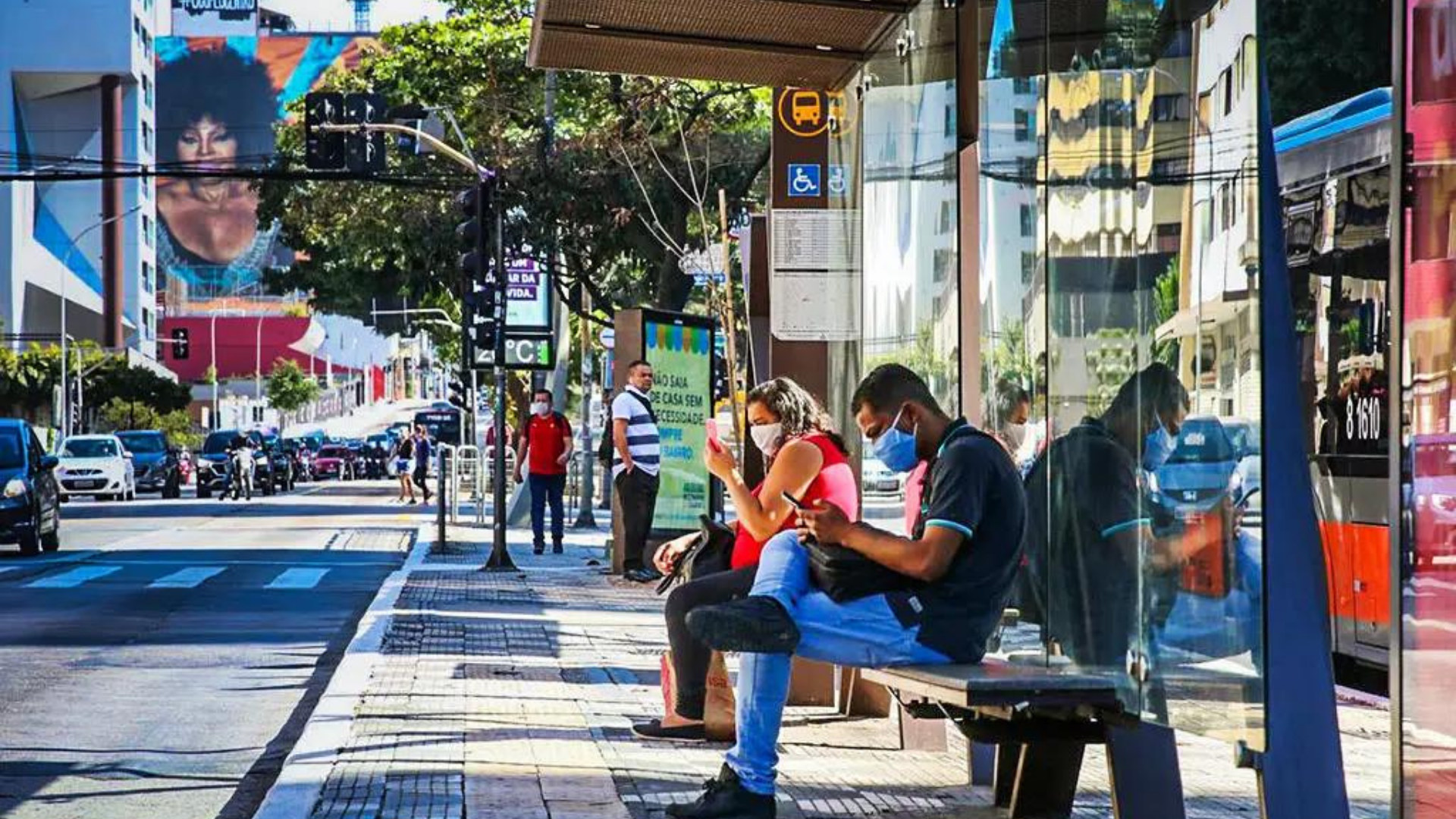 Observatório Covid-19 diz que relaxamento nas medidas de proteção é prematuro. Foto de pessoas em uma parada de ônibus em São Paulo. 