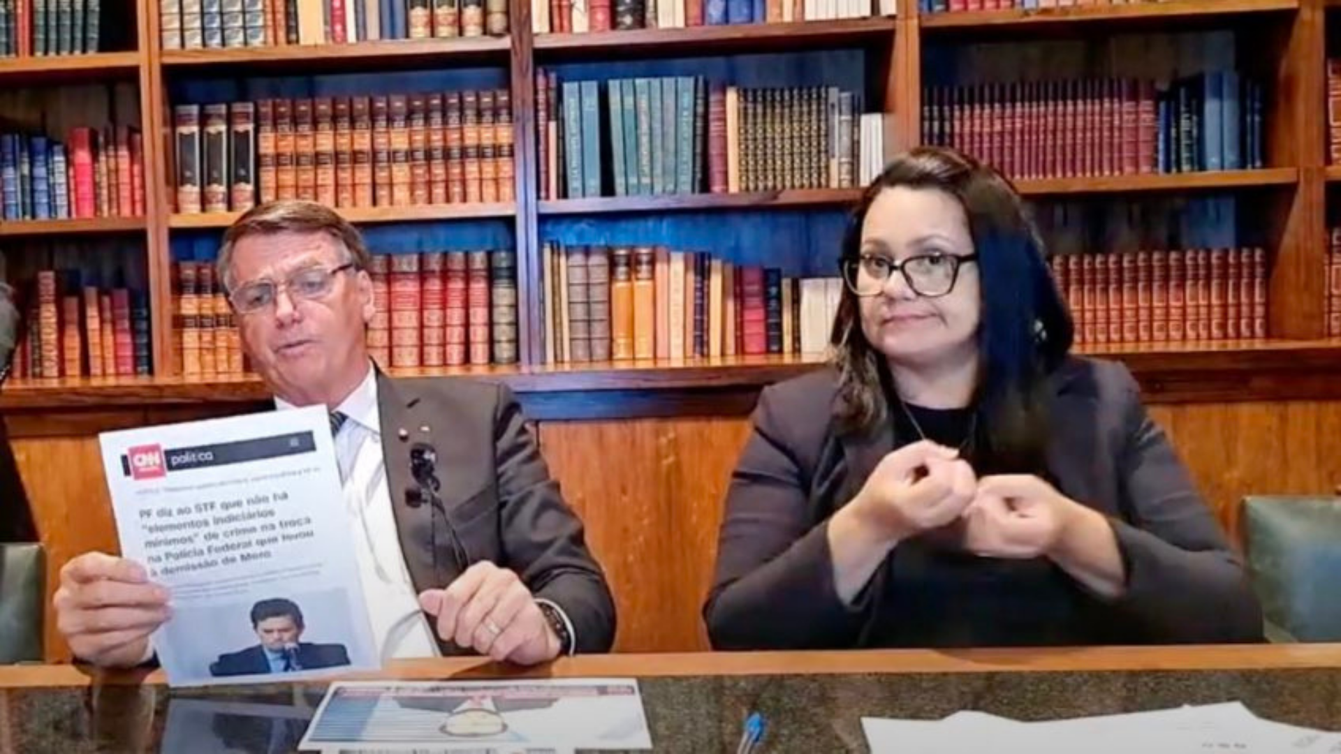 Bolsonaro chama Sergio Moro de “traíra” e “mentiroso”. Foto do presidente em live semanal sentado em uma mesa junto com papéis.