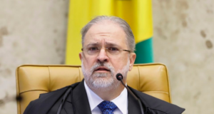 PGR pede arquivamento de processo que investiga Aras. O PGR aparece sentando em cadeira com expressão de preocupação, ele usa terno preto, barba branca e cabelo grisalho.