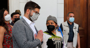 No Chile, Boric acaba com ordem de Piñera que militarizou áreas indígenas. Foto do presidente, de máscara, ao lado de uma liderança mapuche.