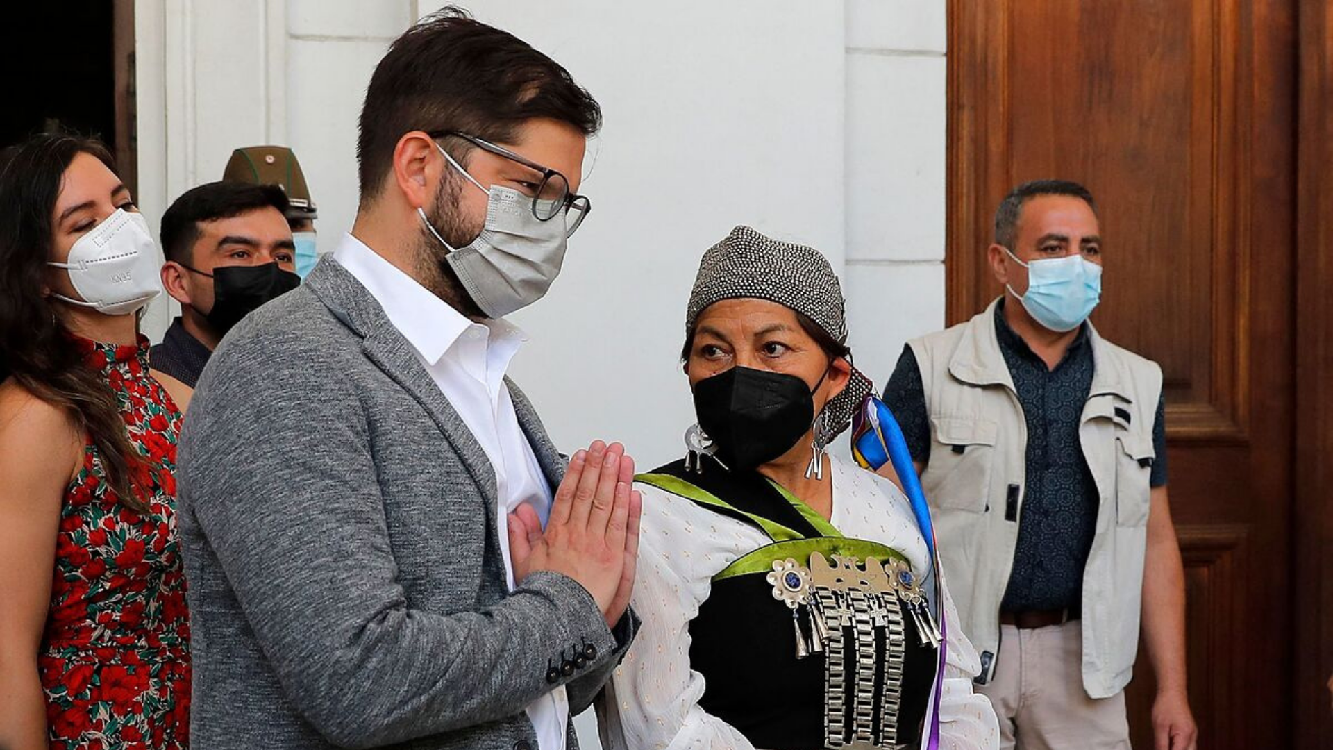 No Chile, Boric acaba com ordem de Piñera que militarizou áreas indígenas. Foto do presidente, de máscara, ao lado de uma liderança mapuche. 