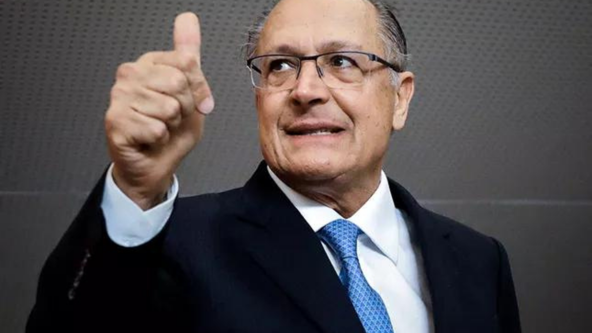 Justiça de SP arquiva acusação de caixa 2 contra Alckmin. Foto de Alckmin usando terno preto e acenando com o polegar.