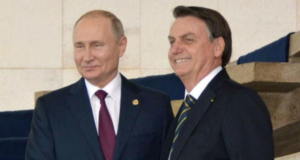 Em live, Bolsonaro chama Putin de "parceiro". Foto dos dois se abraçando em encontro na Rússia.