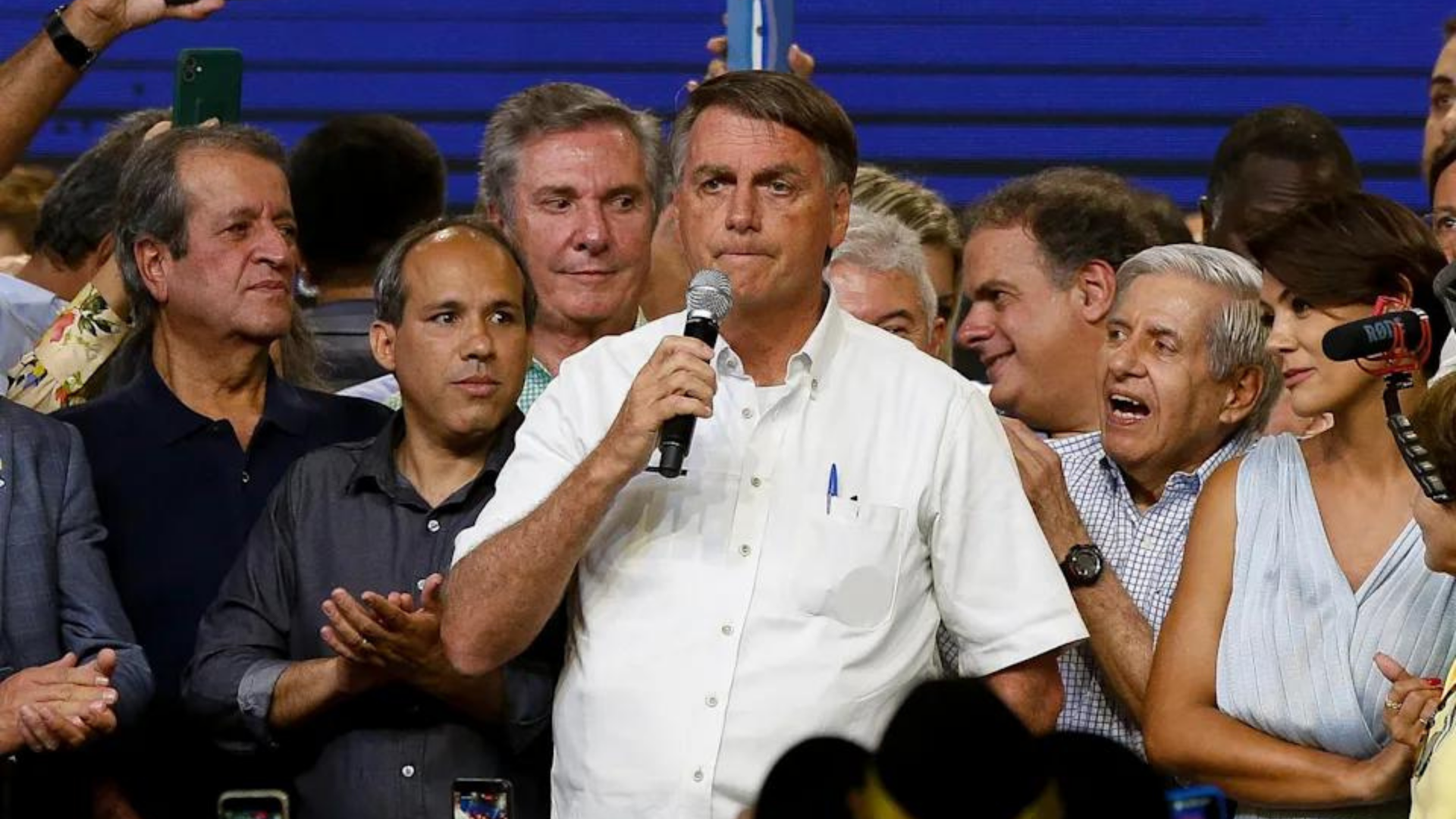 Após demissões, Bolsonaro passa mal e vai parar em hospital. Foto do presidente com expressão de preocupação ao lado de aliados.
