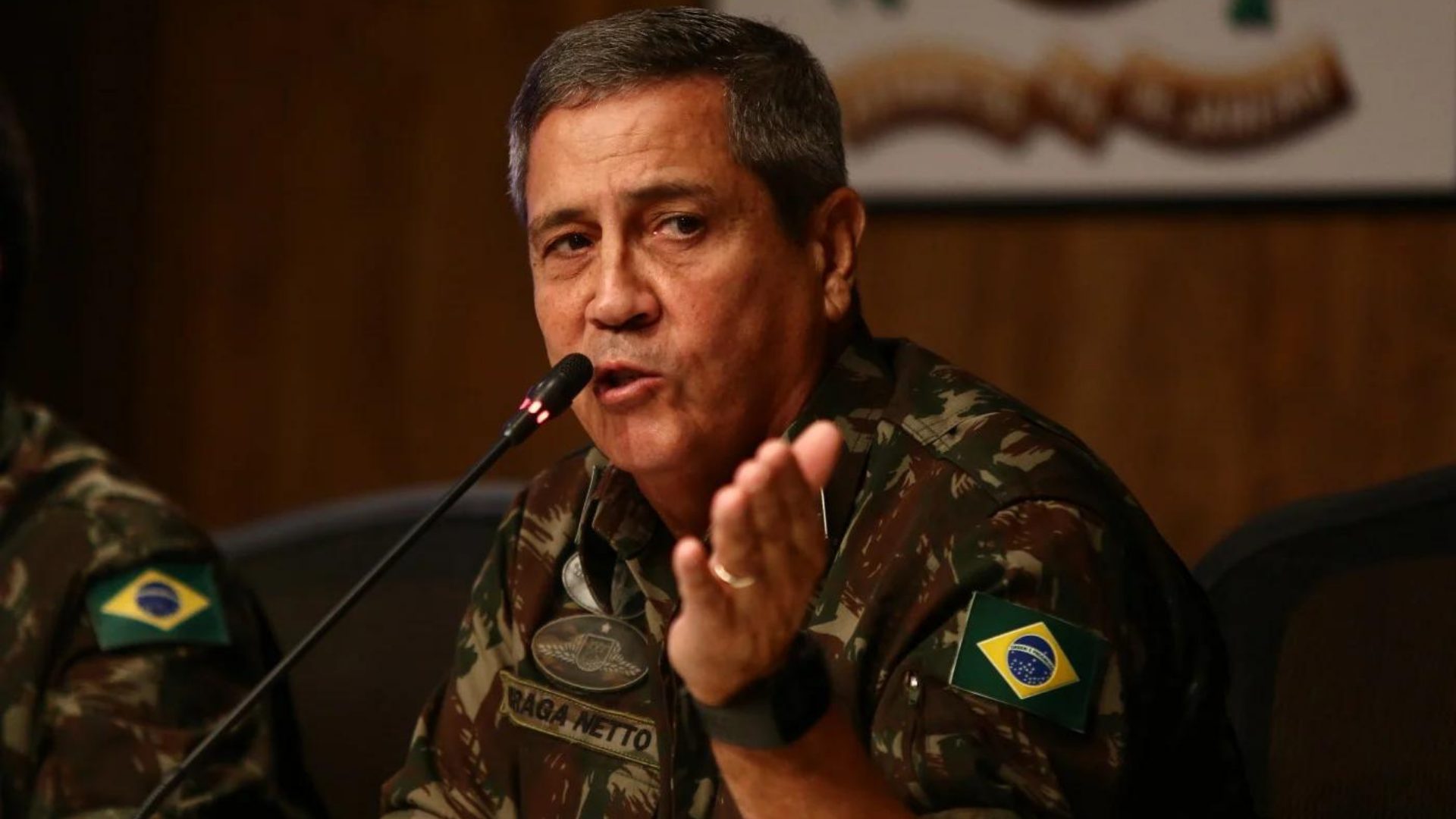 Ministério da Defesa comemora Golpe de 64 em publicação. Foto do ministro Braga Netto com expressão séria enquanto fala ao microfone.