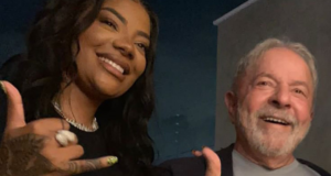 Ludmilla se encontra com o ex-presidente Lula. Eles estão sorrindo abraçados lateralmente.