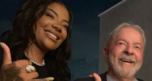 Ludmilla tira foto com Lula e diz que ele está convidado para show. Foto de Ludmilla ao lado de Lula. Ambos estão sorrindo.