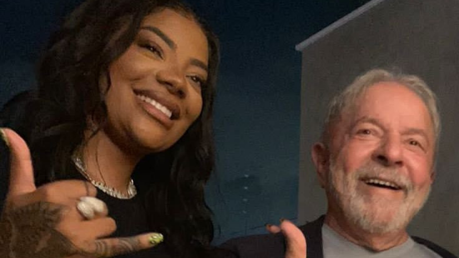 Ludmilla tira foto com Lula e diz que ele está convidado para show. Foto de Ludmilla ao lado de Lula. Ambos estão sorrindo.