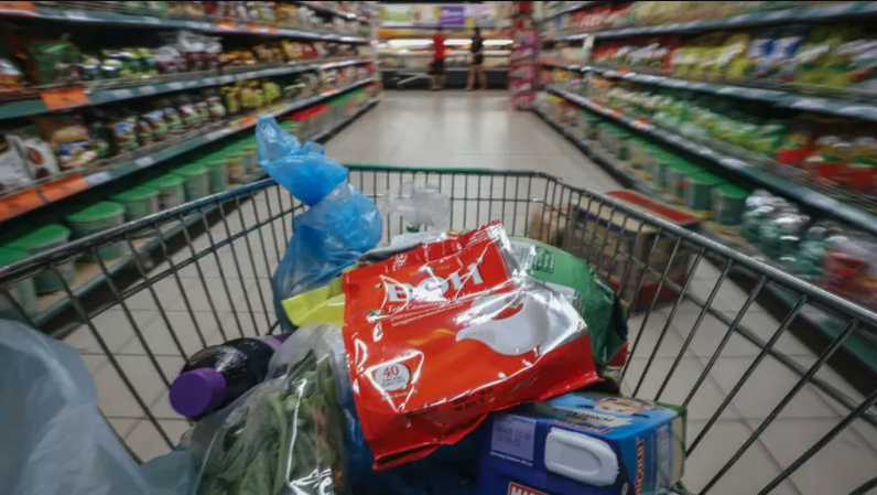 Carrinho de compras com alguns itens em um supermercado; inflação disparou