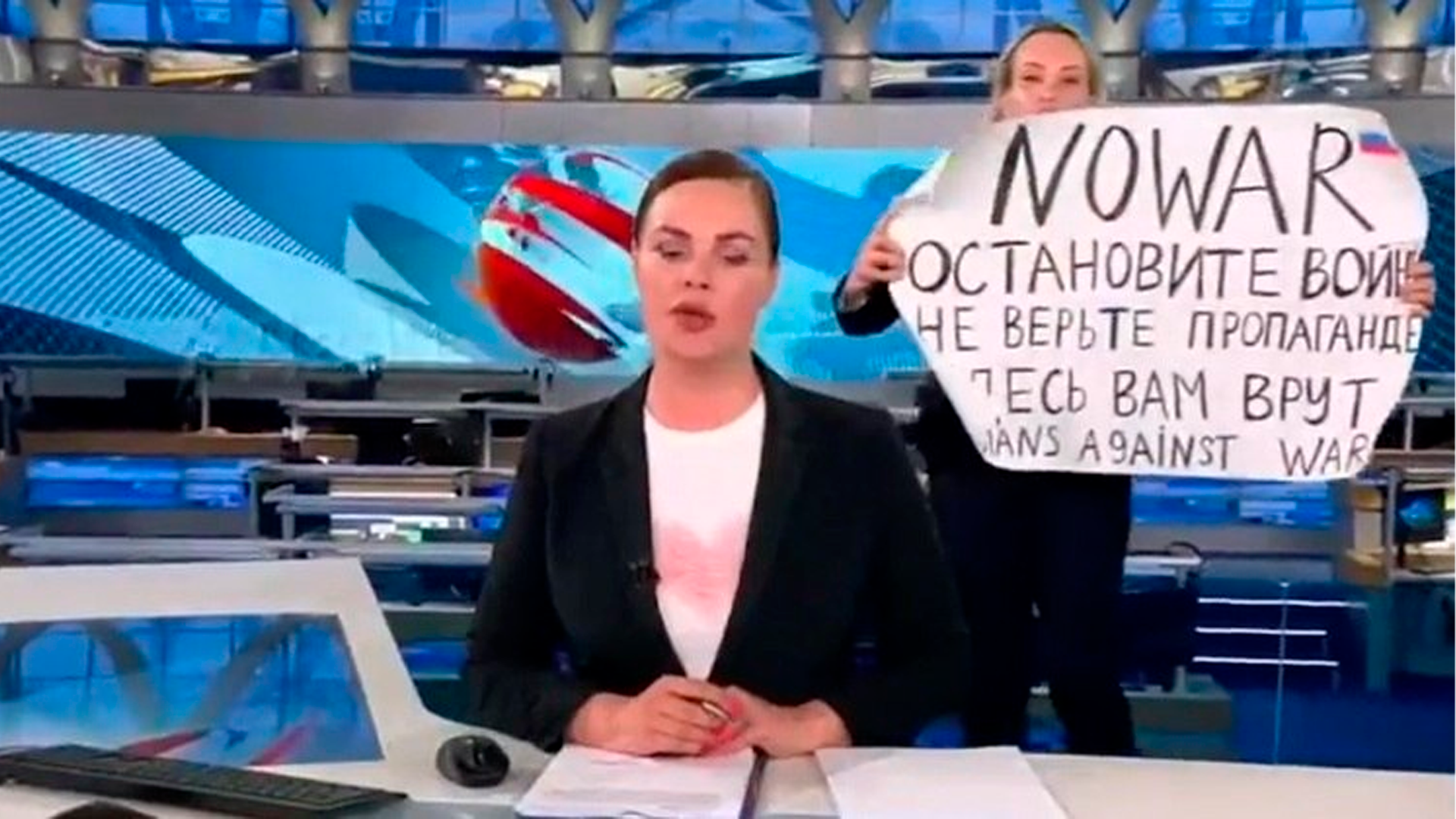 Jornalista com cartaz no telejornal russo