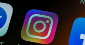 Logo do Instagram na tela de um celular. Ao lado, aparece a logo do Facebook.