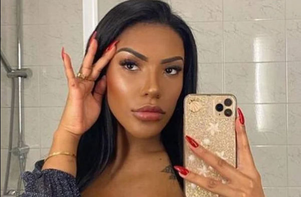 Foto da modelo Carolina Lekker com o celular na mão, em frente ao espelho. A foto mostra apenas seu rosto.