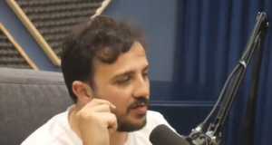 Renan Santos dando entrevista ao podcast Flow. Ele está sentado e há um microfone na sua frente.