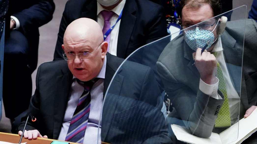 O embaixador da Rússia na ONU, Vasily Nebenzia. Ele está sentado, usa terno e gravata e tem um microfone à sua frente.