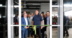 O presidente Jair Bolsonaro (PL) com outras autoridades na cerimônia de cortar a faixa de inauguração do aeroporto. Ele sorri para a foto.