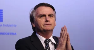 Bolsonaro com as mãos juntas.