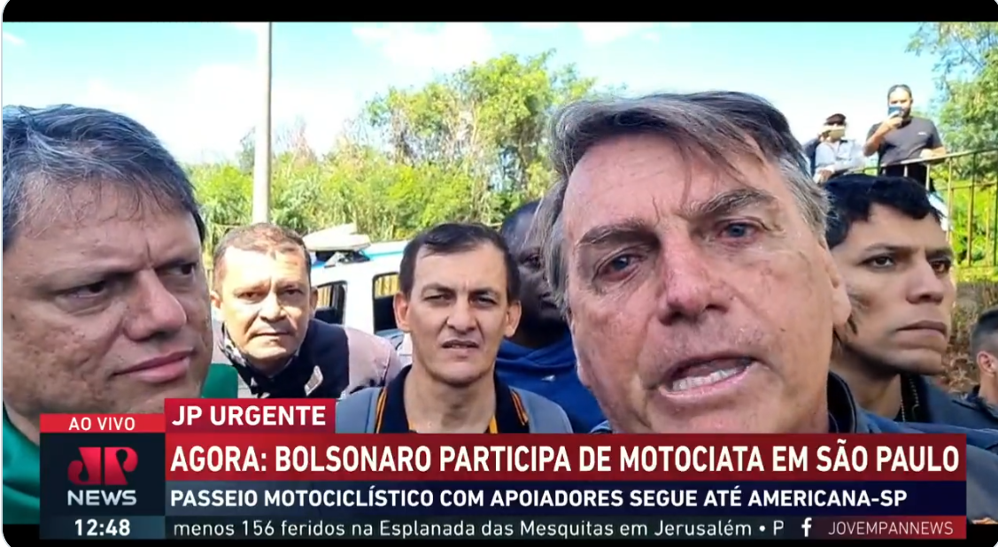 O presidente Jair Bolsonaro (PL) falando durante motociata. Ao seu lado, está Tarcísio de Freitas.