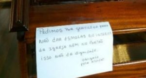 cartaz contra esmolas é colado em banco em igreja