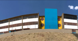Foto do prédio de uma escola em São Paulo, pintada com as cores azul e amarelo.
