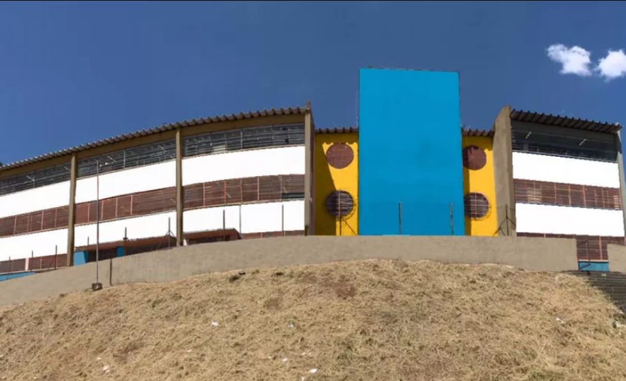 Foto do prédio de uma escola em São Paulo, pintada com as cores azul e amarelo.