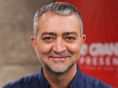 Imagem de Edegar Pretto, com pepe negra, cabelo grisalho e sorridente.