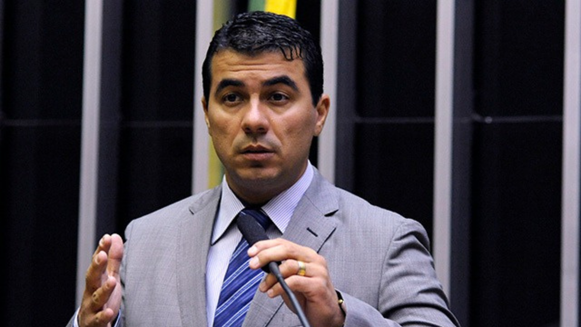 Foto de Luis Miranda no plenário da Câmara usando terno azul e com os braços formando um ângulo de 90 graus.