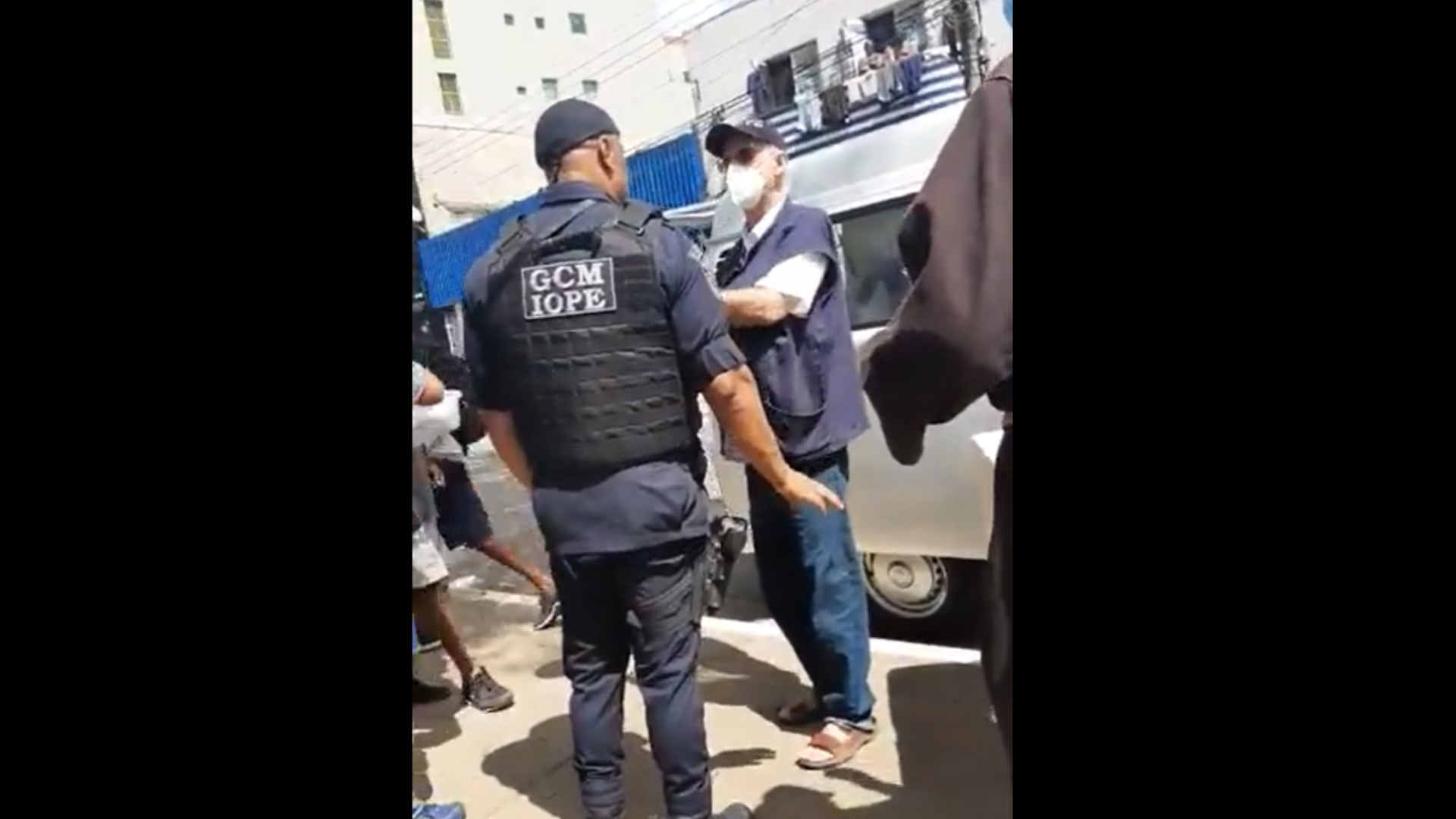 GCM tenta impedir padre Julio Lancellotti de distribuir quentinhas em SP. Foto de Julio Lancelotti discutindo com um agente na rua.