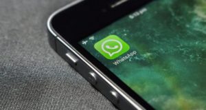 Foto de um celular com o ícone do aplicativo WhatsApp sendo mostrado na tela.