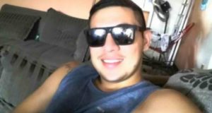 Foto do marinheiro sorrindo com um óculos de sol e cabelo preto.