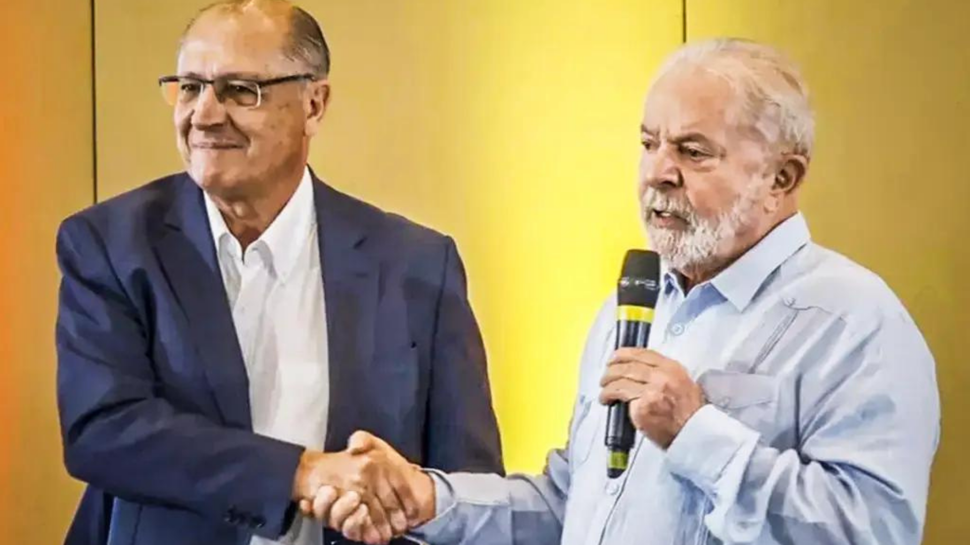 Lula e Alckmin estão no mesmo espaço um ao lado do outro.