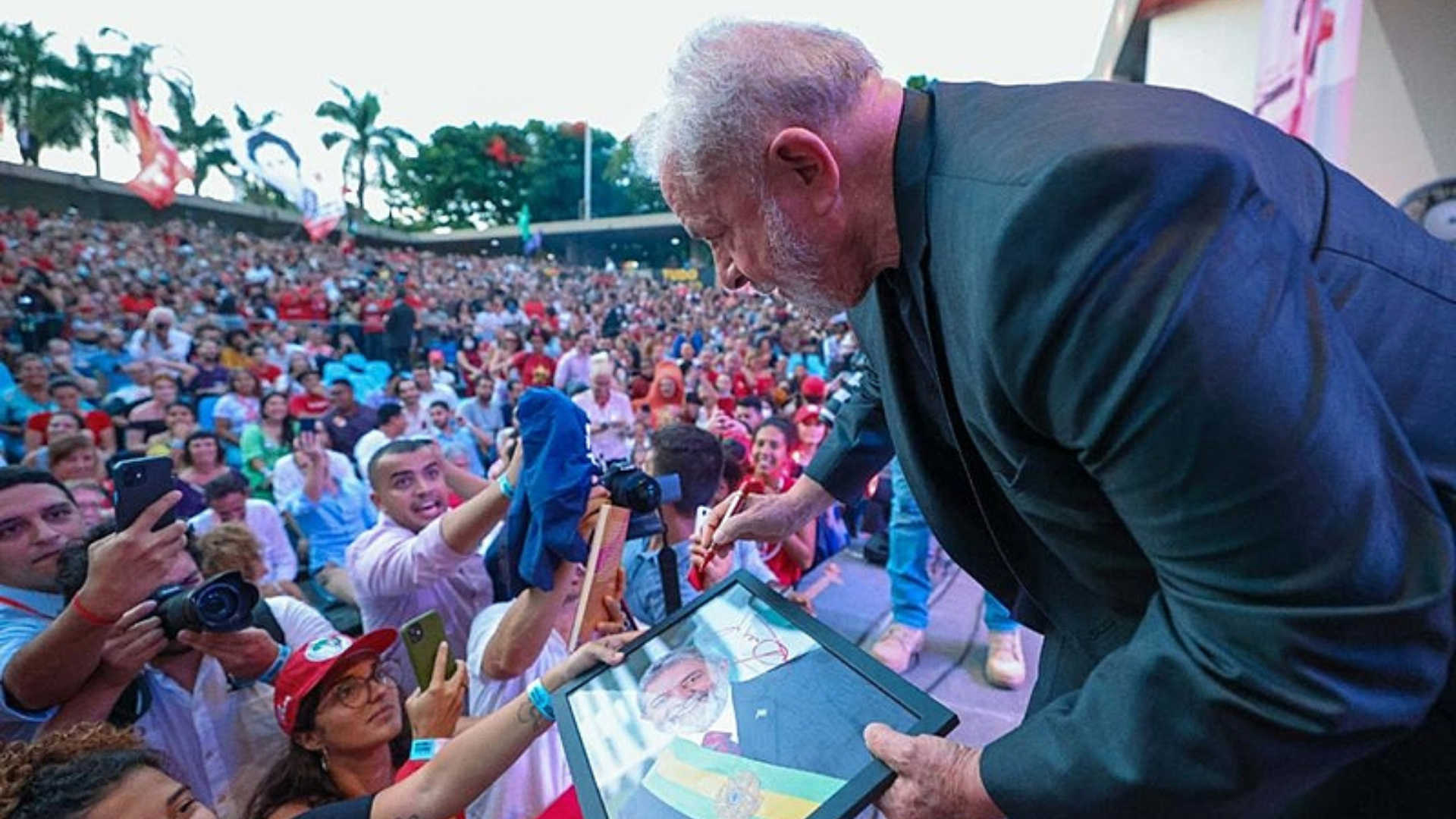 “Já ouço Lula presidente”, diz o ator Rodrigo Lombardi. Foto de Lula com a cabeça abaixada falando com uma apoiadora.