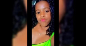 Raquel aparece em uma self. ela tem cabelos cacheados e pele negra.