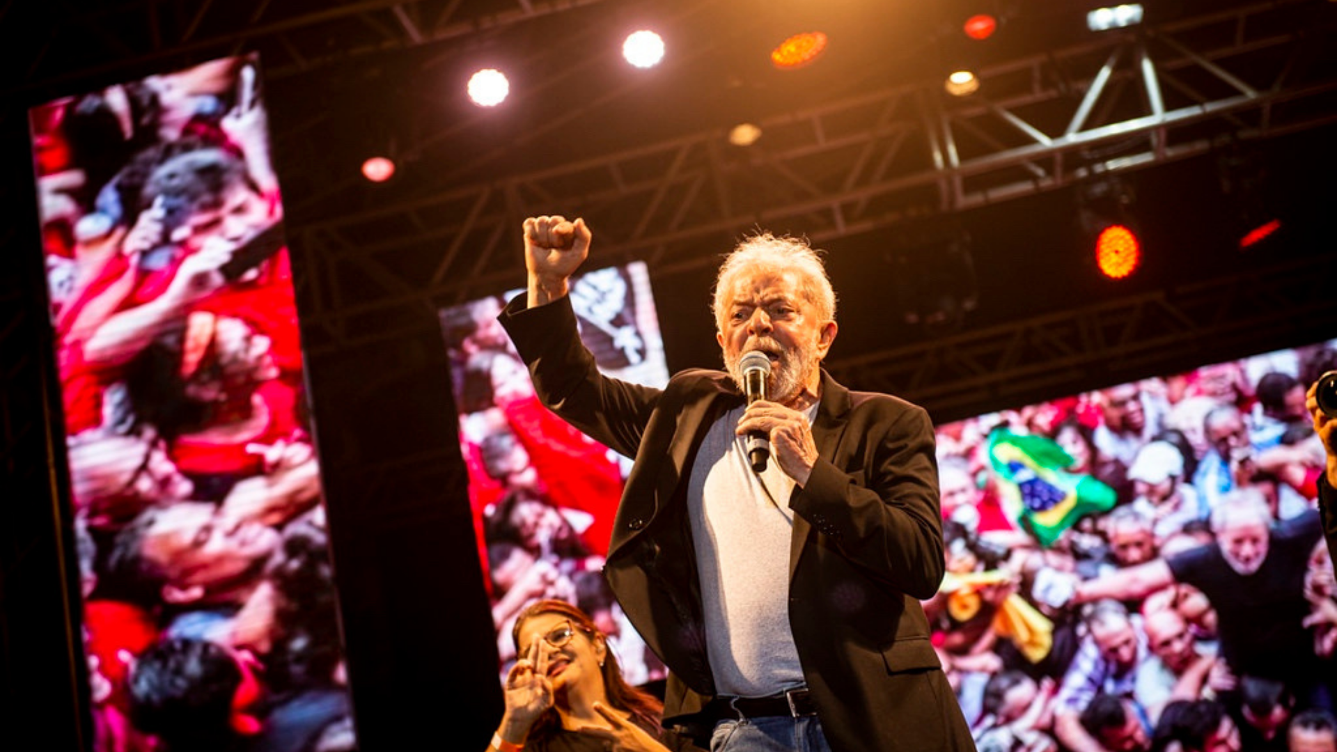 Lula aparece disparado em primeiro lugar no Maranhão; veja os números. Foto do presidente falando no microfone em um palco.