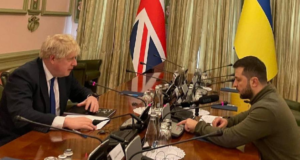 Boris Johnson se reune com Zelesnky. Os dois estão em uma mesa de reunião.