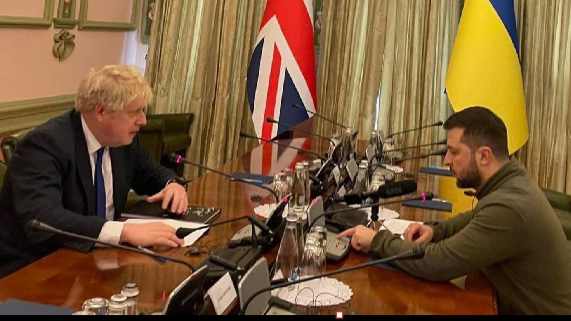 Boris Johnson se reune com Zelensky. Os dois estão em uma mesa de reunião.