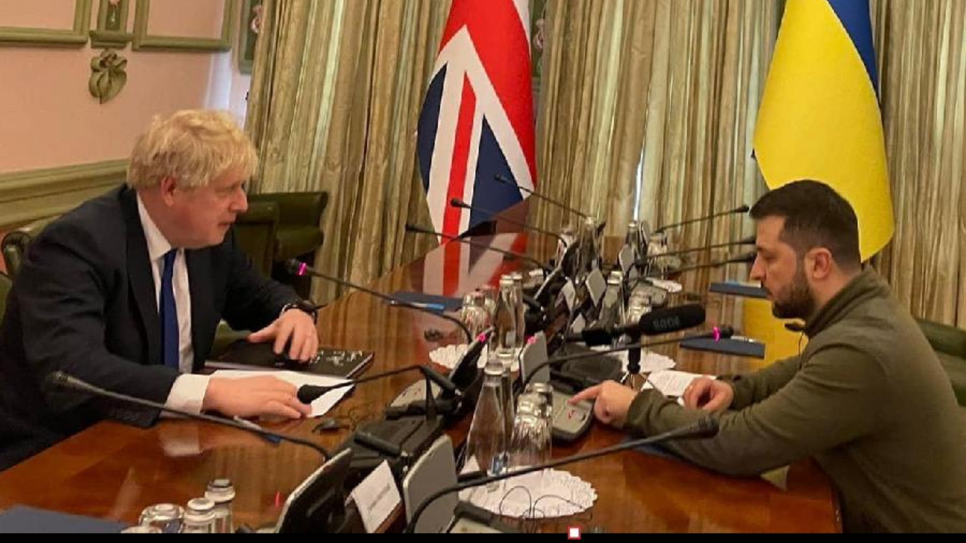 Boris Johnson se reune com Zelensky. Os dois estão em uma mesa de reunião. 