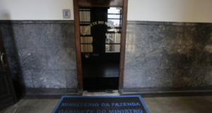 Foto do escritório de Bolsonaro com um tapete e porta de vidro.