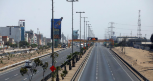 Foto de uma longa rodovia no Peru com carros e caminhões circulando.