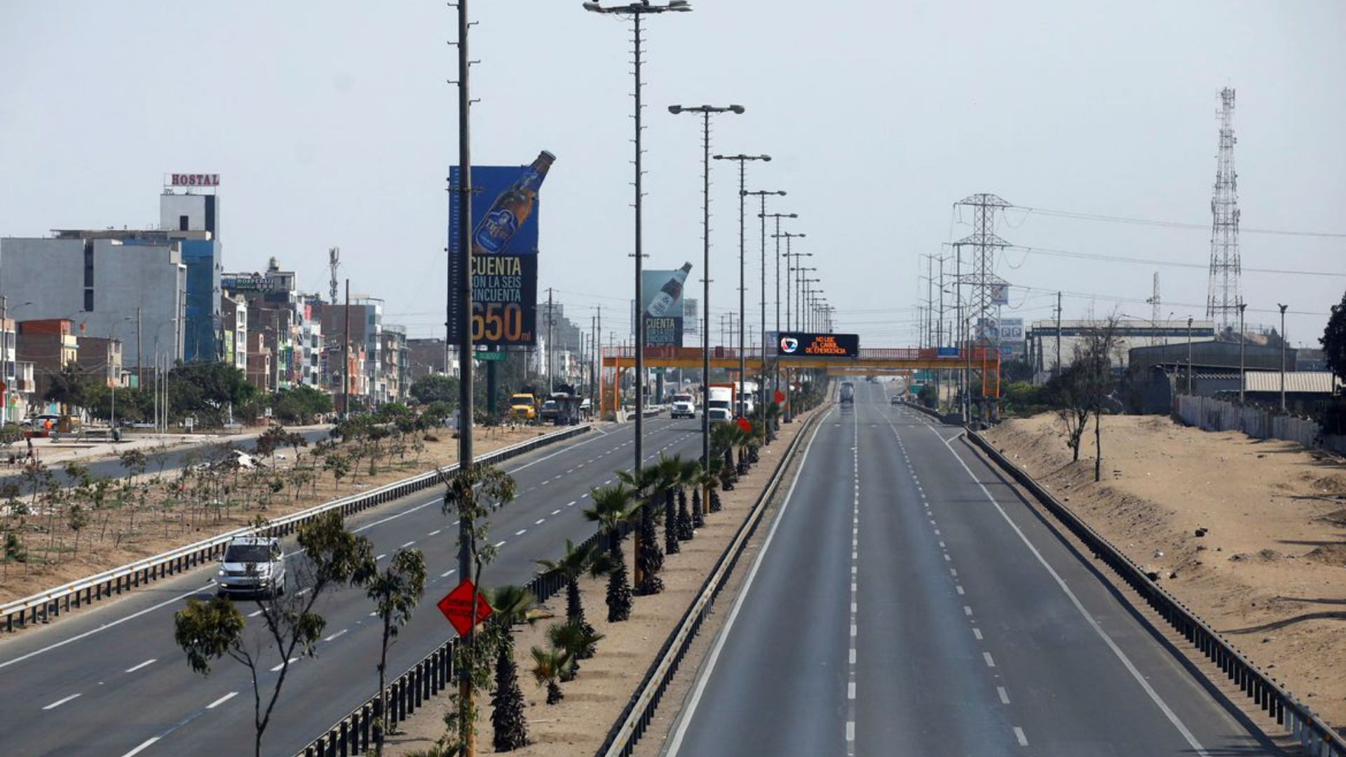 Foto de uma longa rodovia no Peru com carros e caminhões circulando.