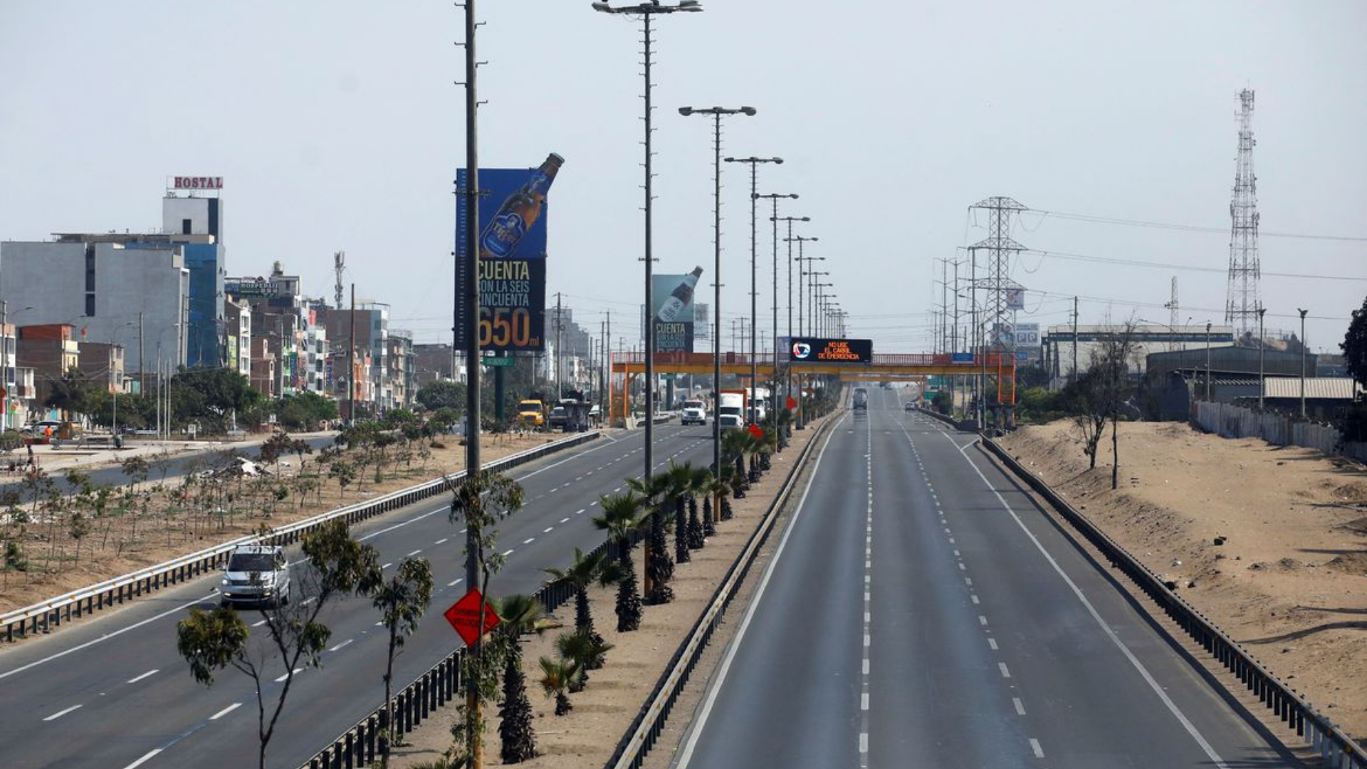 Foto de uma longa rodovia no Peru com carros e caminhões circulando. 